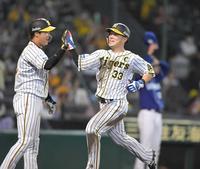 　５回、糸井の適時打で生還した糸原（右）は、大山とタッチを交わす