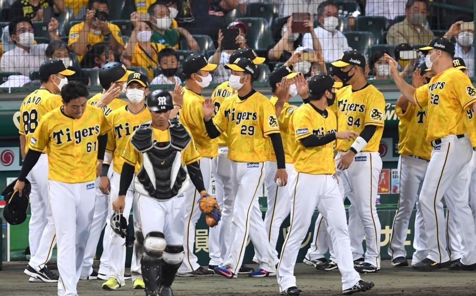 ウイニングボールを手に勝利のハイタッチを交わす阪神・高橋遥人（中央）ら＝甲子園（撮影・飯室逸平）