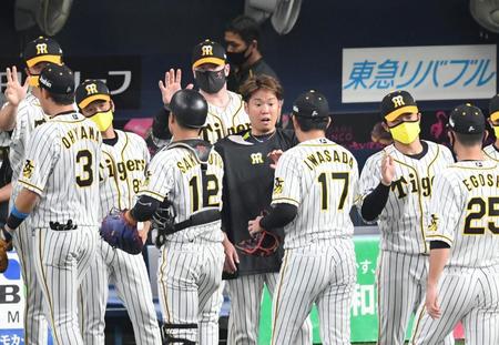 阪神・西勇輝（中央）は試合を締めた阪神・岩貞祐太を迎える＝京セラドーム大阪（撮影・山口登）