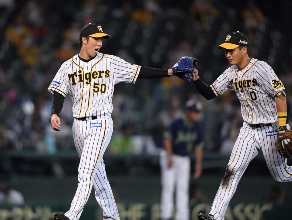 　６回、併殺に仕留めた木浪とタッチを交わしながらベンチへ戻る阪神・青柳晃洋