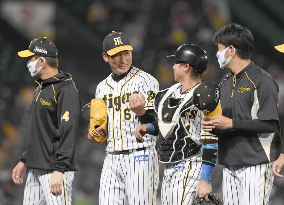 　プロ初セーブの岩崎（左から２人目）は岩貞（右）から手渡されたウイニングボールを手に笑顔を見せる