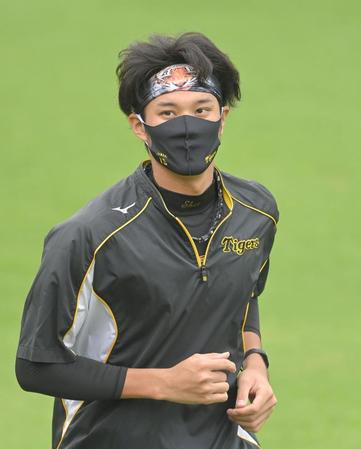 試合前、虎柄のヘアバンドを巻いて練習する藤浪
