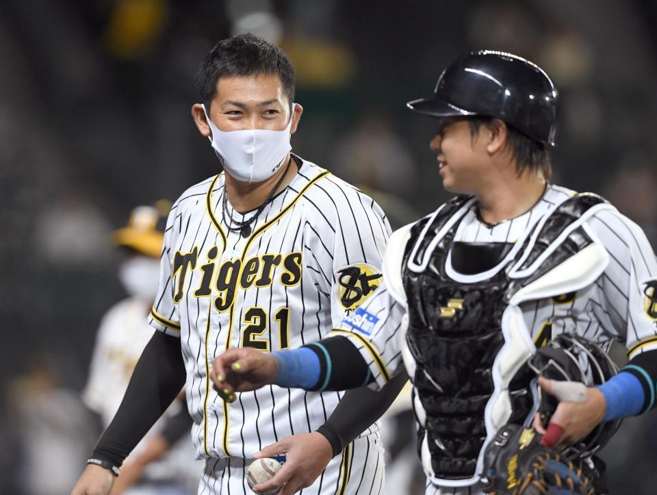 　今季初勝利を挙げた岩田（左）は梅野と喜び合う