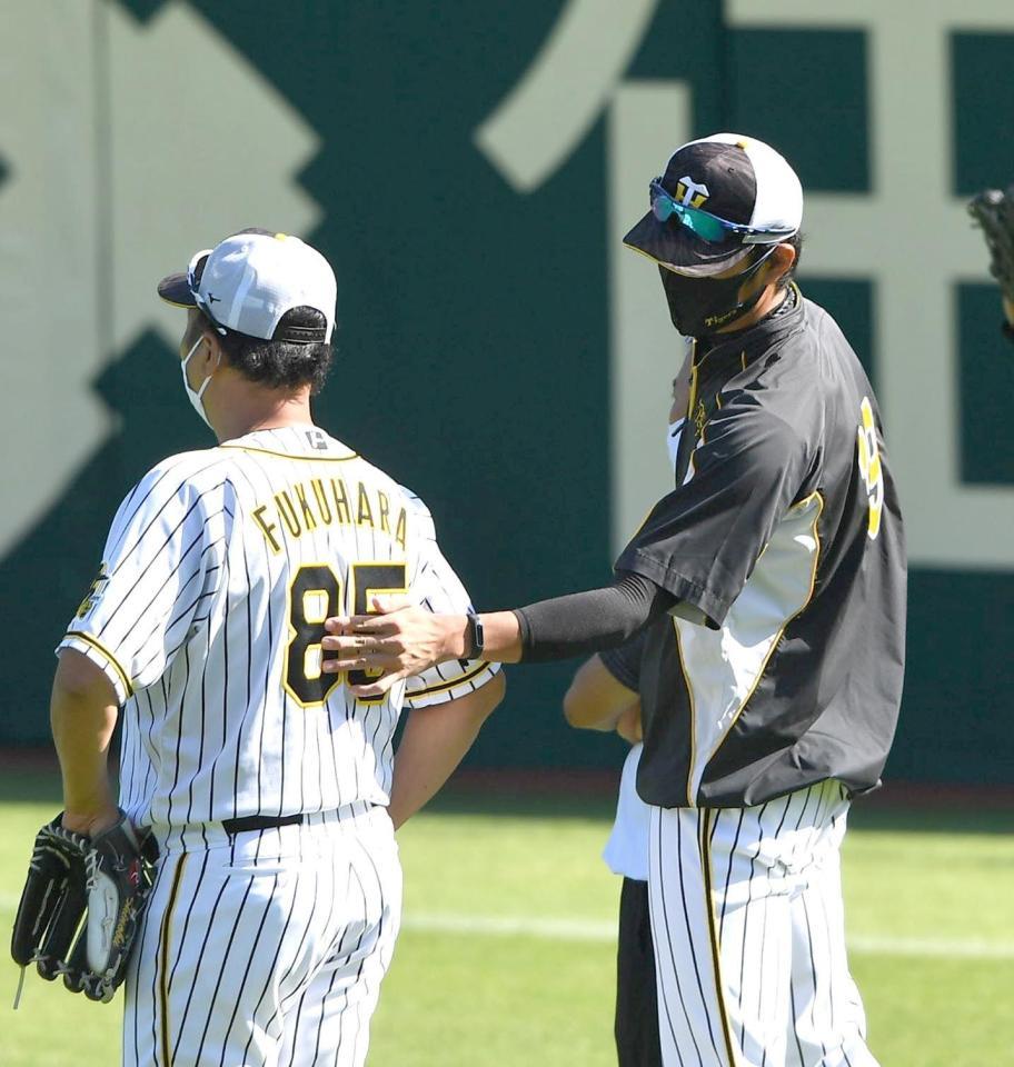 　練習中、福原コーチ（左）の背中に手をやる阪神・藤浪（撮影・北村雅宏）