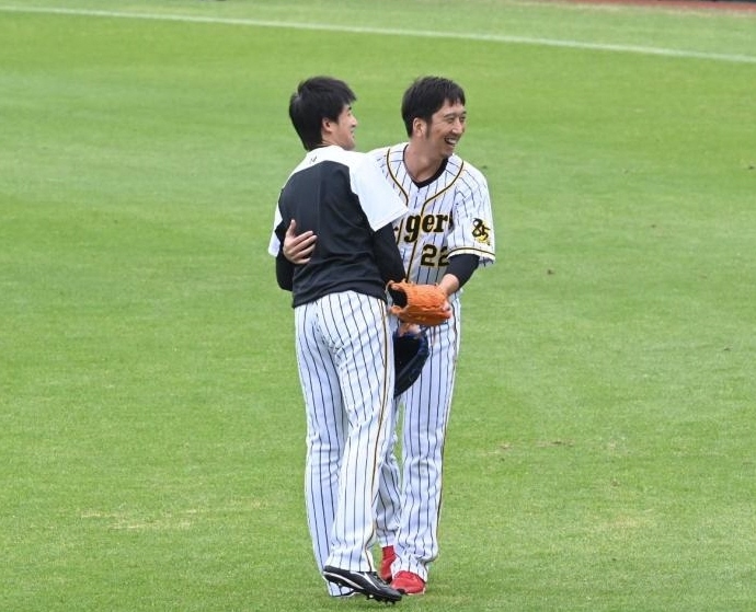 キャッチボールを終え、笑顔で抱擁する阪神・能見（左）と藤川