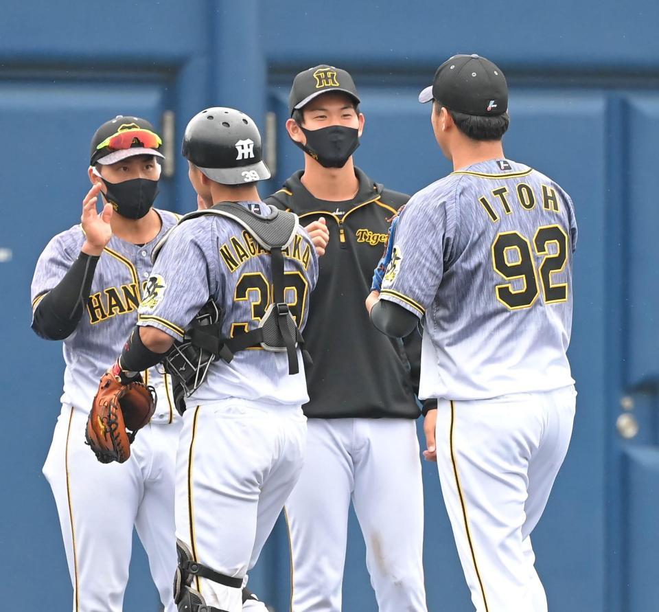 オリックスに勝利し、最後を締めた阪神・伊藤和雄（右端）らを迎える阪神・及川雅貴（中央）＝オセアンバファローズスタジアム舞洲（撮影・高部洋祐）