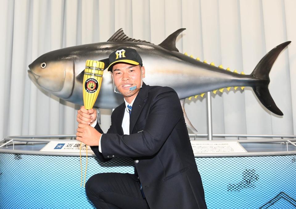　阪神から１位指名を受け、近大マグロの前でプロでの活躍を誓う近大・佐藤＝２６日