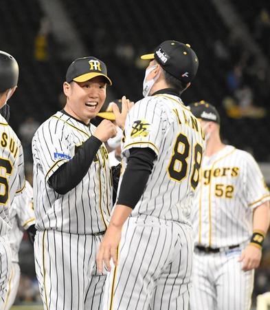　完投勝利を挙げ、矢野監督とタッチを交わす西勇（左）＝撮影・北村雅宏
