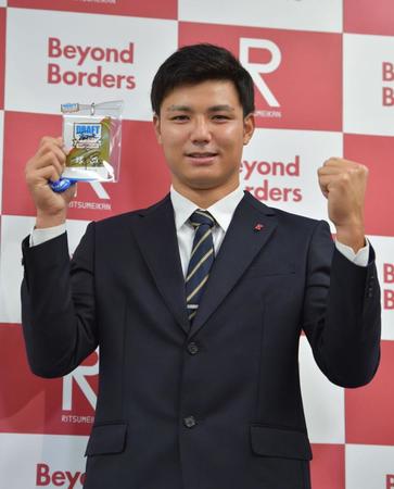 矢野監督のサイン入りＩＤを手に笑顔の阪神ドラフト４巡目の立命大・栄枝裕貴＝立命館大学衣笠キャンパス（撮影・神子素慎一）