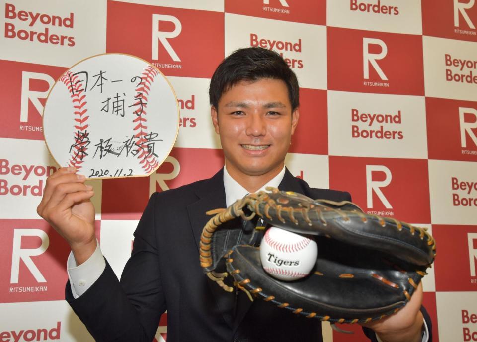 目標を書いた色紙を掲げる阪神ドラフト４巡目の立命大・栄枝裕貴＝立命館大学衣笠キャンパス（撮影・神子素慎一）