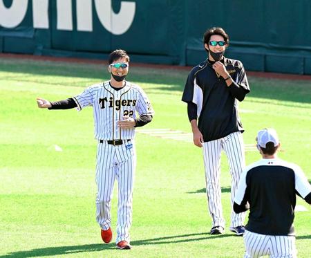 　練習中、笑顔で言葉を交わす藤川（左）と藤浪