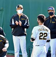 　練習前、藤川（22）らと共に投手陣の円陣に入る岩貞（左）