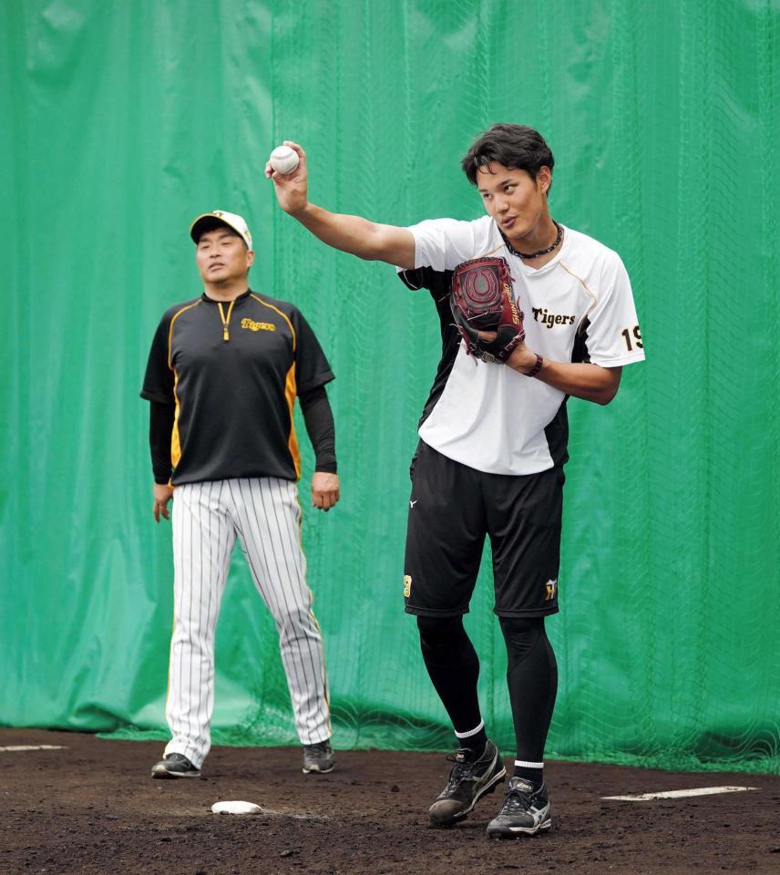 　２月のキャンプで投球フォームを確認する藤浪を見守る山本昌臨時コーチ（左）