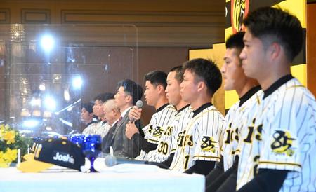 あいさつする阪神・佐藤輝明（中央）。仕切りを取り付けて入団発表を行った＝大阪市内のホテル（撮影・田中太一）