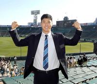 　グラウンドを背に両手でガッツポーズを決める佐藤輝