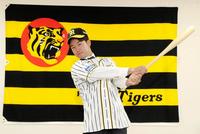 ユニホームにそでを通し、バットを手に活躍を誓う山本＝球団事務所（代表撮影）