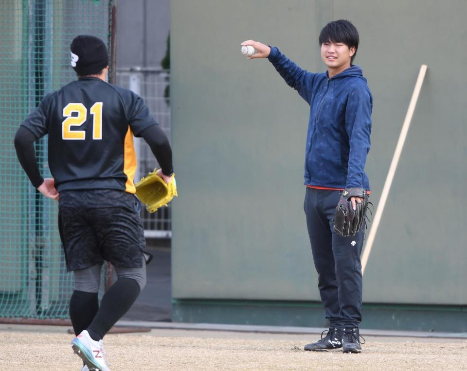 　岩田稔（左手前）とキャッチボールをする牧
