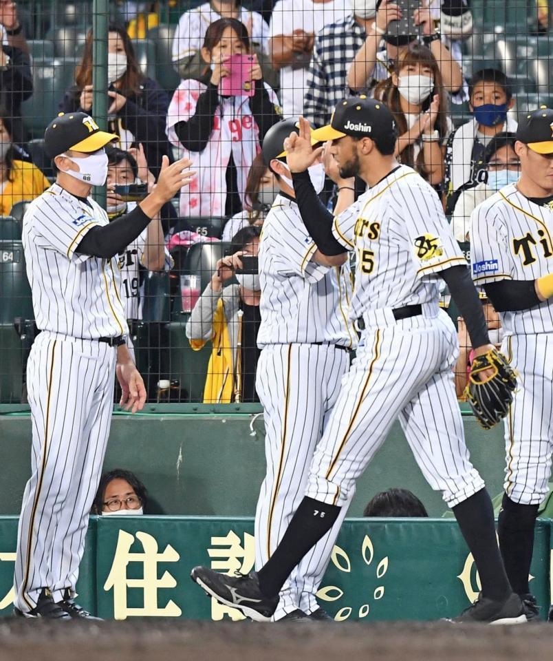 　中日戦で無失点に抑え、矢野監督（左）の出迎えを受けるスアレス＝１０月１日、甲子園