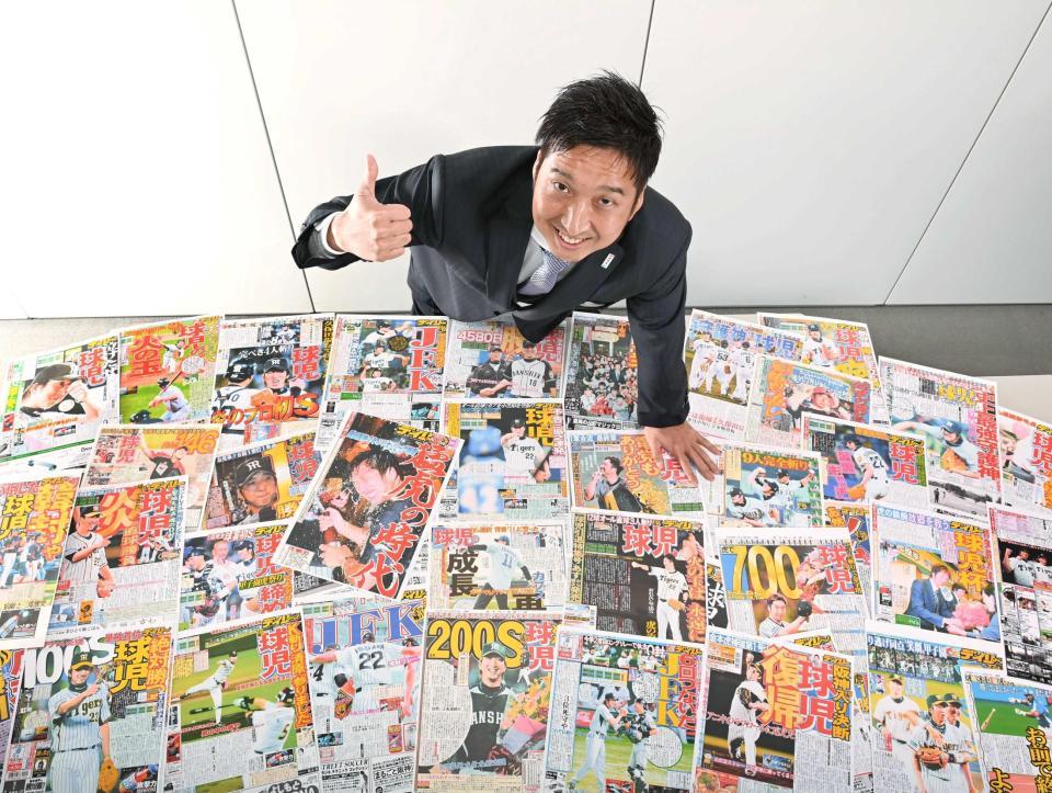 　現役時代の活躍を報じたデイリースポーツを前にポーズを決める藤川球児氏（撮影・飯室逸平）