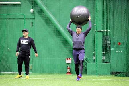 　バランスボールを投げる大山（球団提供）