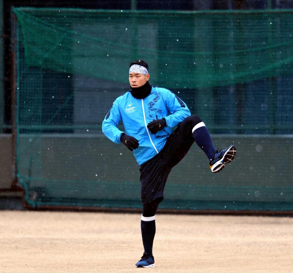 　雪が降る中、ウォーミングアップをする佐藤輝（撮影・田中太一）