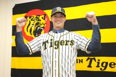 入団会見後、フォトセッションで笑顔を見せる阪神チェン・ウェイン＝甲子園（代表撮影）