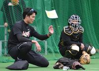 　ブルペンでの投球後、坂本（右）と話する藤浪