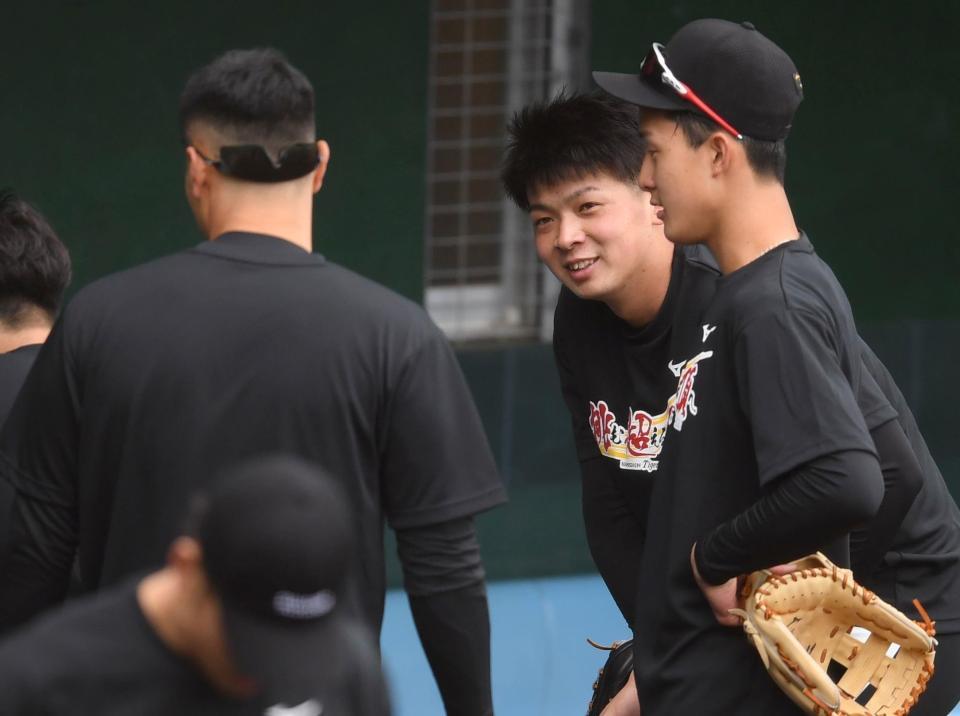 　佐藤輝（左）と話をする井上（右奥）