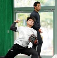 　ブルペンで投げ込む西純。奥は佐藤蓮