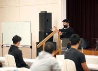 「カッコ良く」と書かれたホワイトボードの横で話す矢野監督（球団提供）