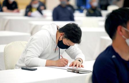 　全体ミーティングでメモをとる大山（球団提供）