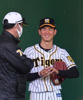 　ブルペンで投球後、高橋コーチと笑顔で話す及川（右）＝撮影・北村雅宏