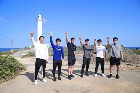 　残波岬灯台を背にポーズを決める佐藤輝（左から３人目）ら阪神新人選手（球団提供）