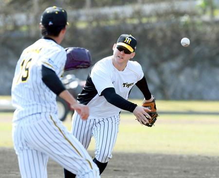 　一塁に入り、ベースカバーに走る藤浪（左）にトスするサンズ（撮影・山口登）