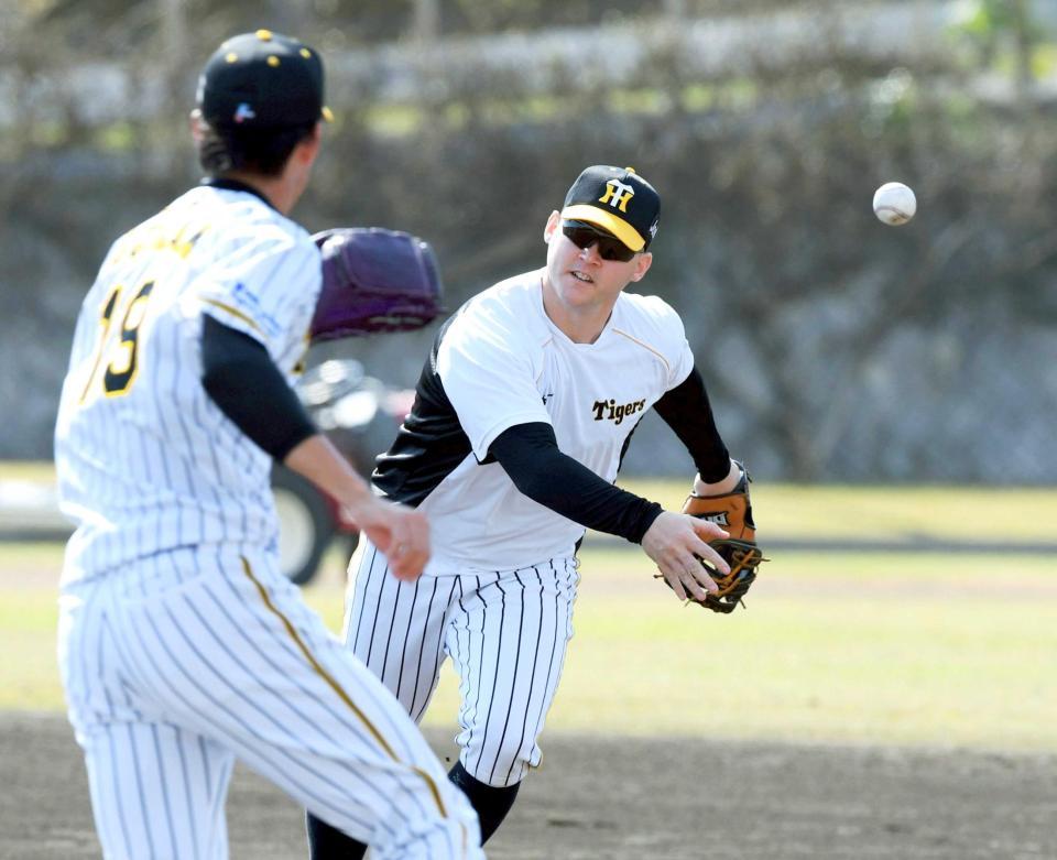 　一塁に入り、ベースカバーに走る藤浪（左）にトスするサンズ（撮影・山口登）