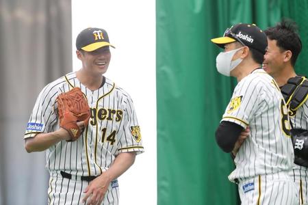 ブルペンで投球練習を終えた阪神チェン・ウェインは（左）は、阪神・矢野燿大監督に声を掛けられ笑顔を見せる＝宜野座