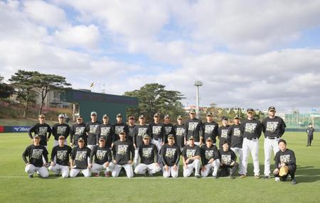 　スアレスＴシャツを着て、スアレス（前列左から５人目）を囲む阪神投手陣と矢野監督（後列左端）＝球団提供