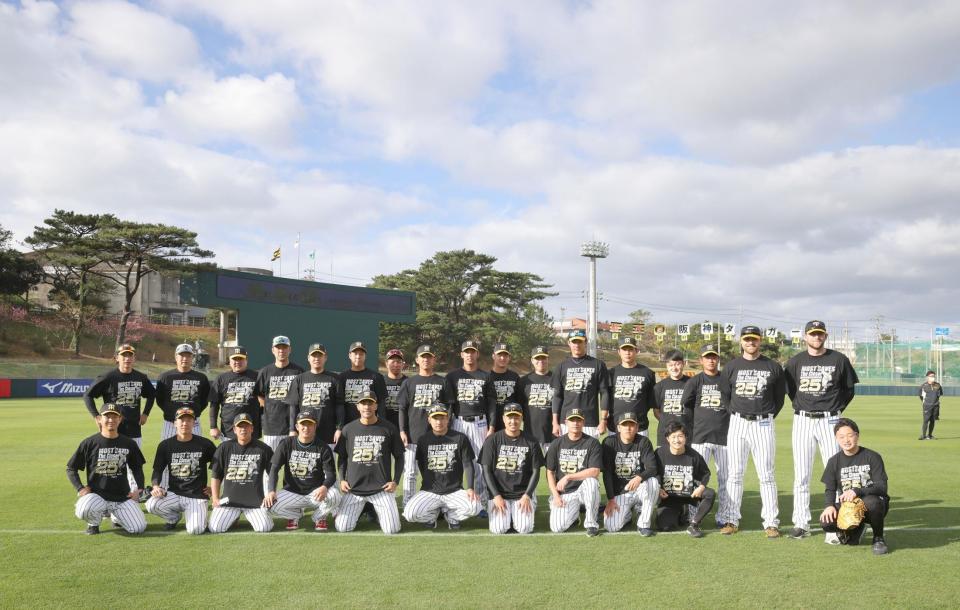 　スアレスＴシャツを着て、スアレス（前列左から５人目）を囲む阪神投手陣と矢野監督（後列左端）＝球団提供