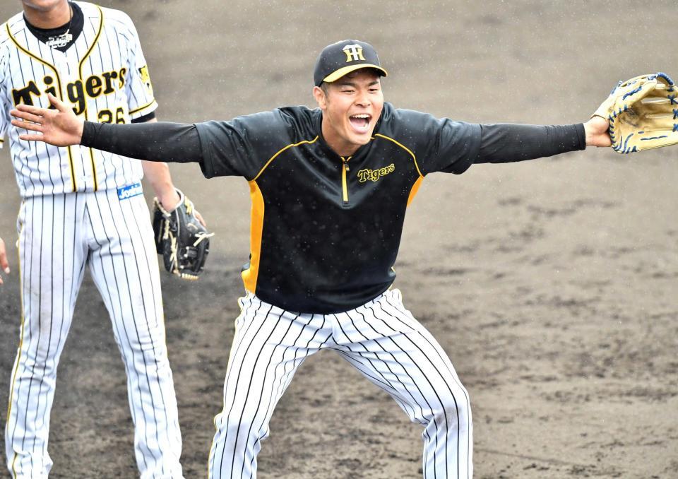 　内野の守備練習で両手を広げて気合を入れる佐藤輝（撮影・田中太一）