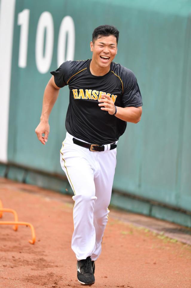 笑顔でミニハードルを使った練習をする阪神・佐藤輝明＝コザしんきんスタジアム（撮影・高石航平）