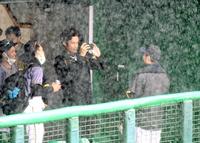 　試合開始直前に降り出した豪雨。藤浪（中央）はスマートフォンで先発予定の青柳（右）を写真に納める