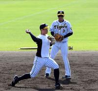 試合前、ノックを受ける阪神・佐藤輝明（右は阪神・大山悠輔）＝宜野座（撮影・山口登）