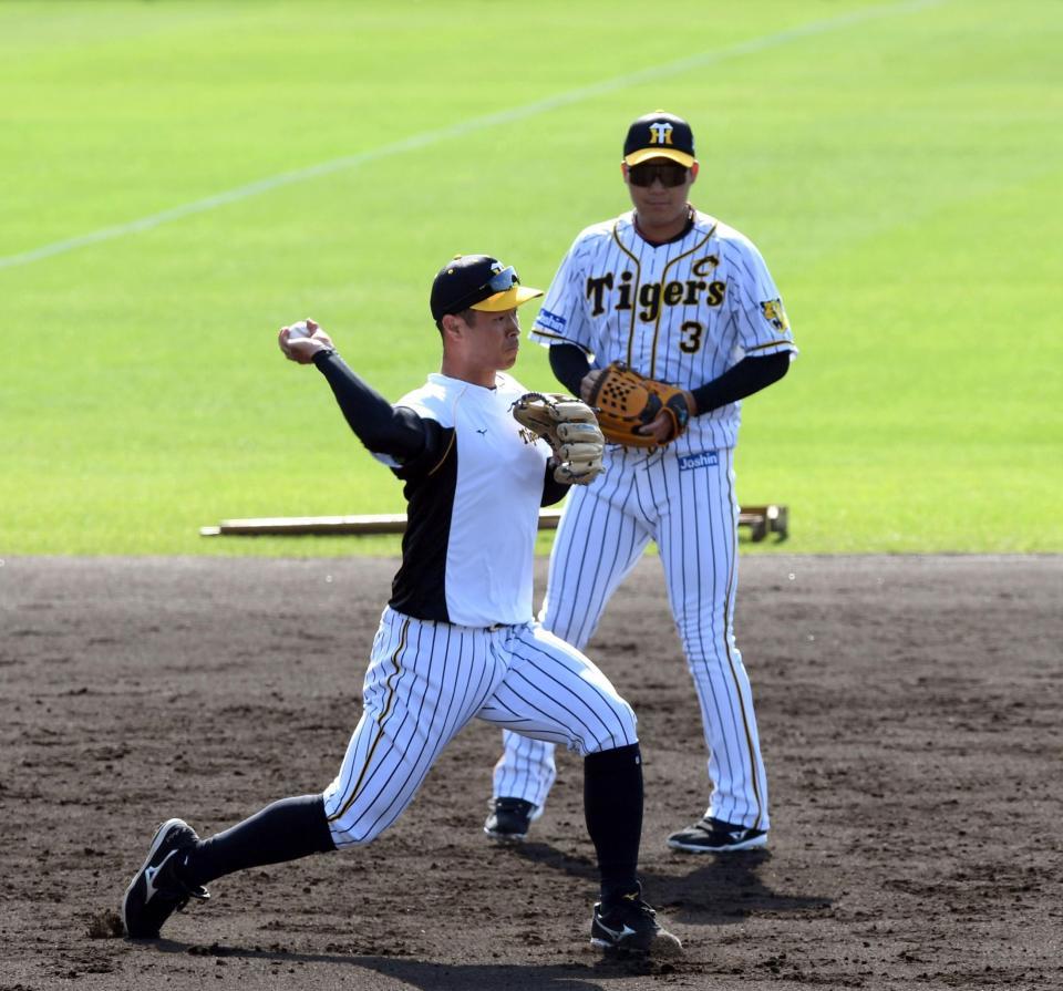 試合前、ノックを受ける阪神・佐藤輝明（右は阪神・大山悠輔）＝宜野座（撮影・山口登）