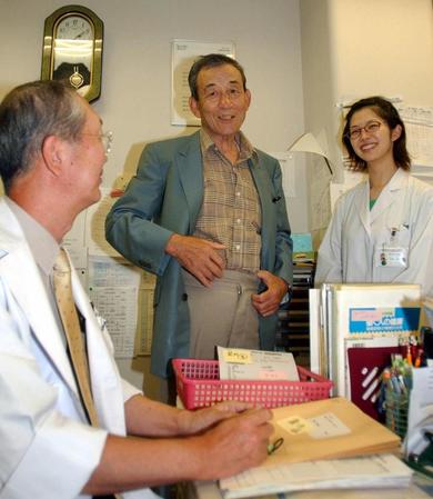 　病院スタッフに囲まれ、談笑する三宅秀史さん＝０４年