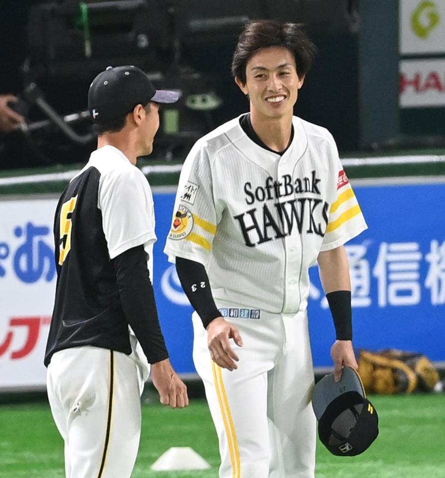 　談笑するソフトバンク・周東と阪神・近本（撮影・飯室逸平）
