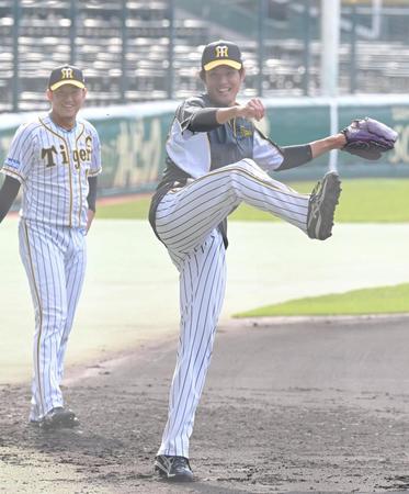 　ノックを受け、勢いよく返球する藤浪。左は岩貞（撮影・高部洋祐）