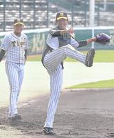 　ノックを受け、勢いよく返球する藤浪。左は岩貞（撮影・高部洋祐）