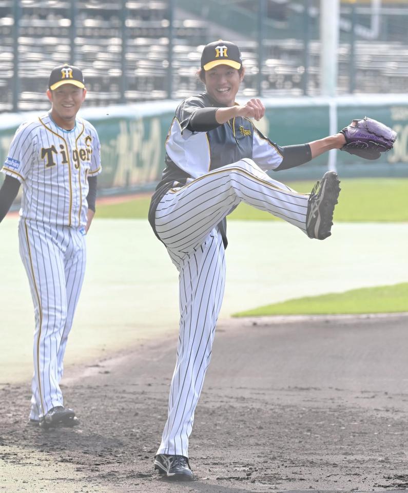 　ノックを受け、勢いよく返球する藤浪。左は岩貞（撮影・高部洋祐）