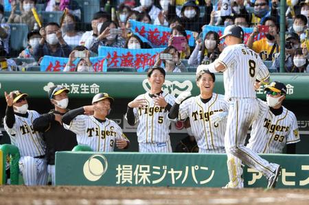 　５回、２ランを放った佐藤輝（右手前）を“ゴリラポーズ”で迎える近本（中央）らナイン