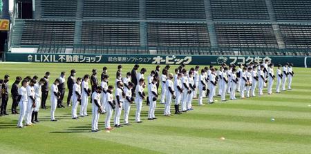 東日本大震災から１０年。阪神ナインは練習前黙とうする＝甲子園（撮影・山口登）